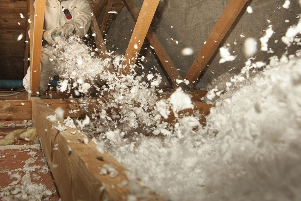 Blown-in insulation being installed in an attic.